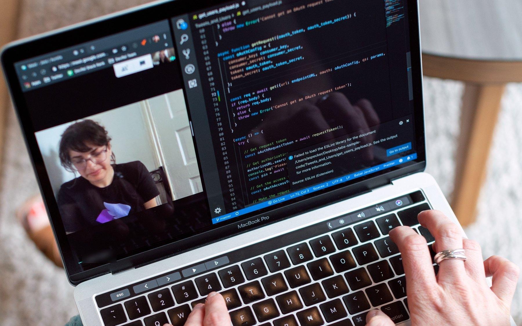 A developer writing code at home while on a call with a teammate